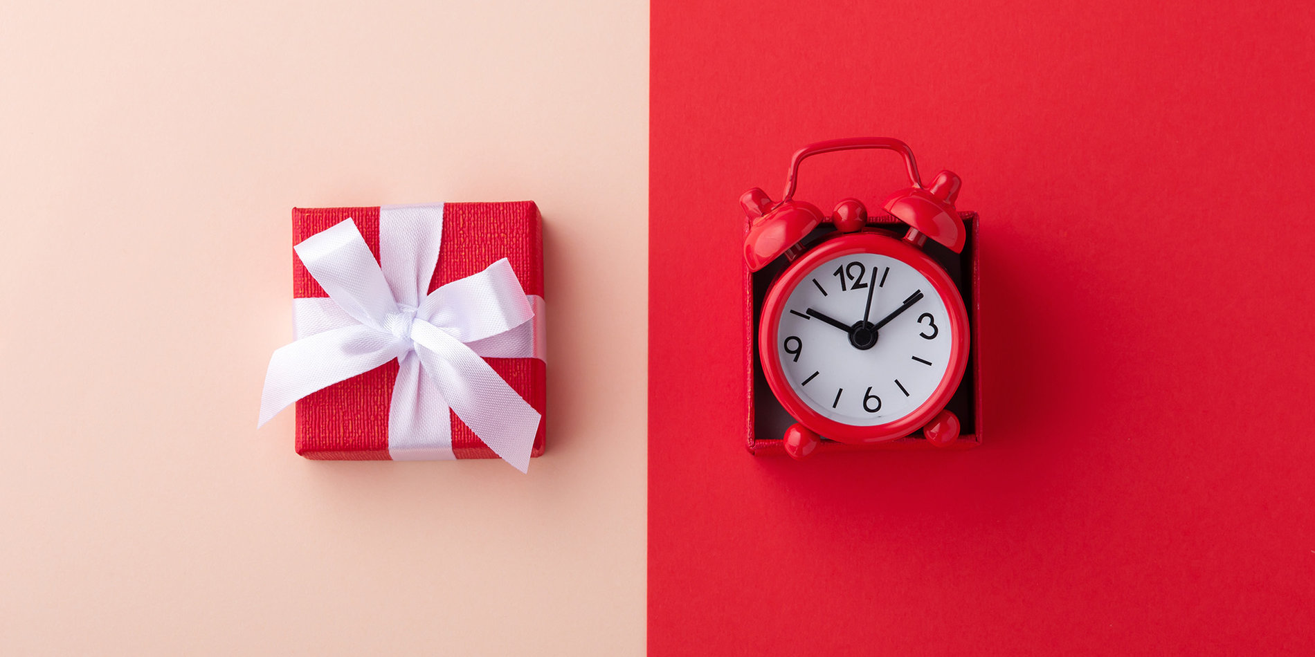 Gift box and red clock on pink and red background