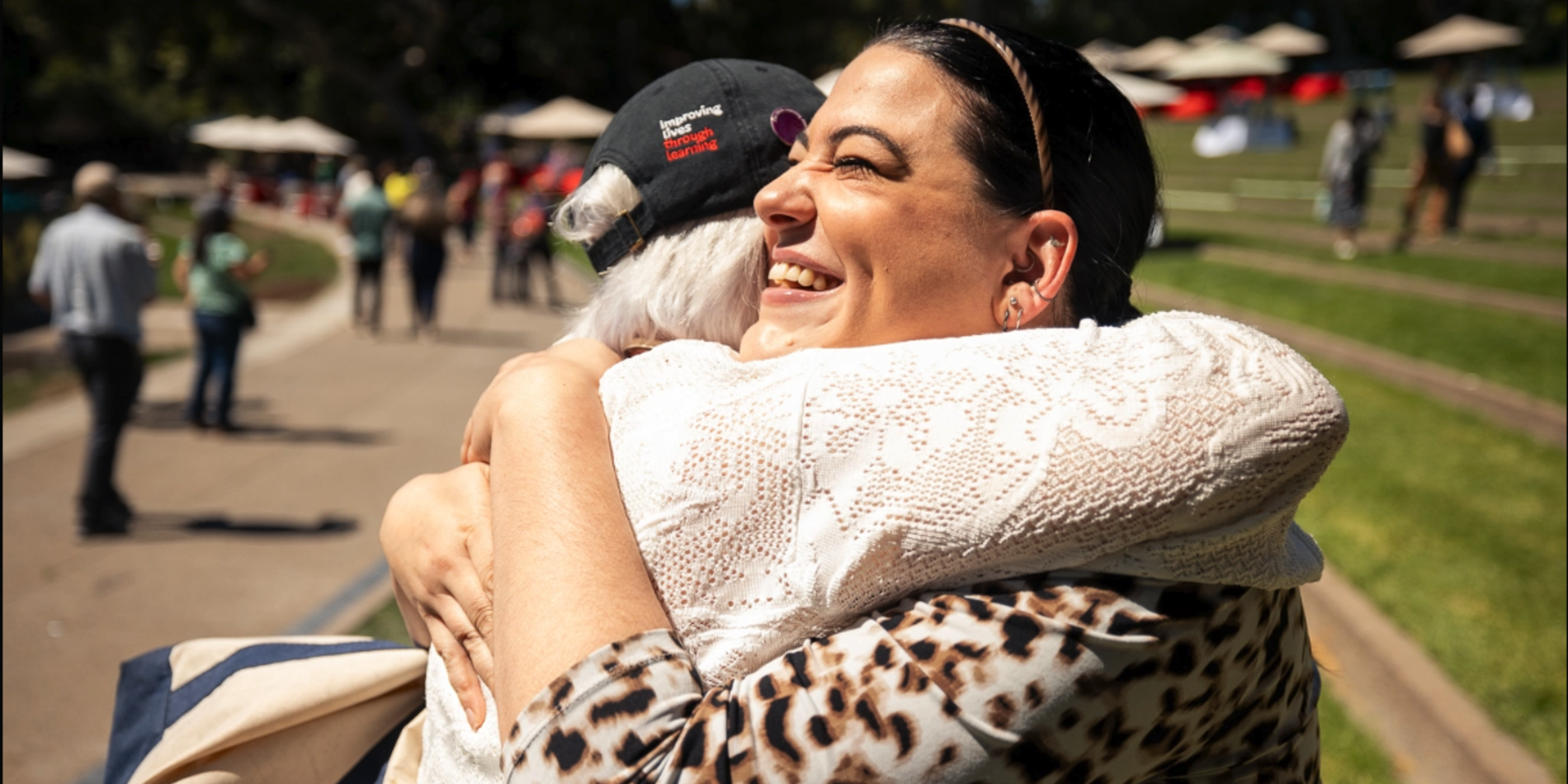 Two Stanford staff hug with joy seeing each other again at the Welcome to Fall event
