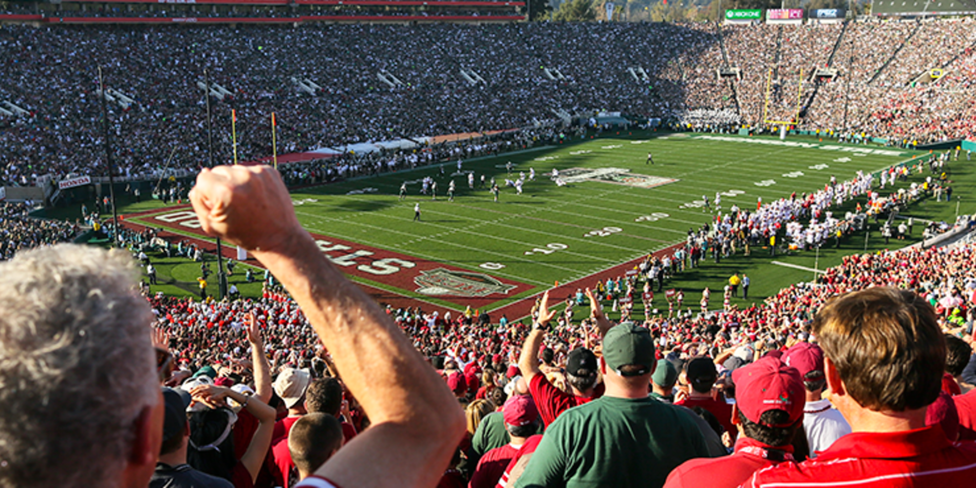 Fans in audience cheer on Stanford's football team at the Stanford Stadium