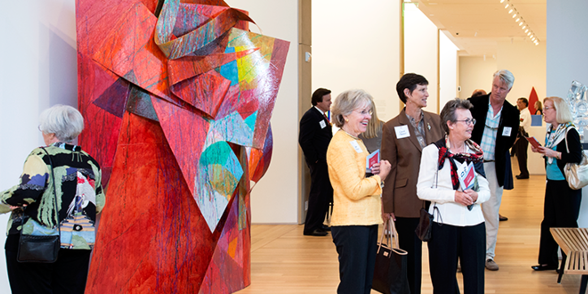 Group of visitors admiring multicolored sculpture art inside the Anderson Collection.
