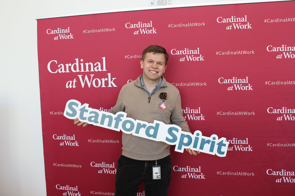 Stanford employee holding Stanford spirit sign