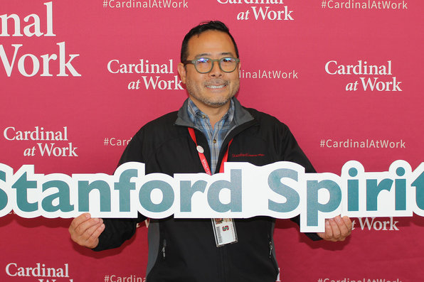 Stanford employee holding Stanford spirit sign
