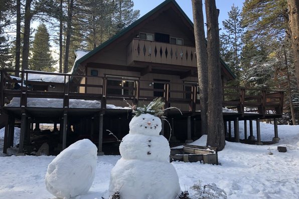 Snowman by a cabin