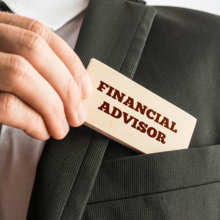 Worker pulling card from suit pocket that says "financial advisor" on it