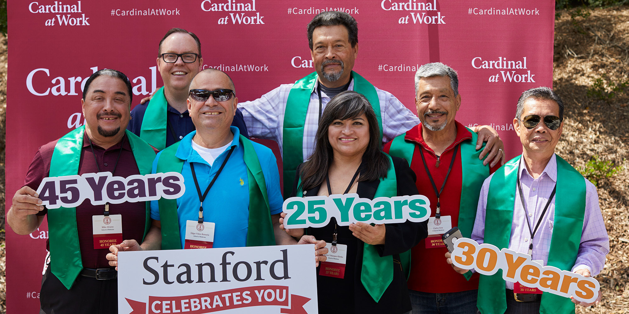 Photo of employees posing with CaW backdrop at Stanford Celebrates You/Service Recognition event